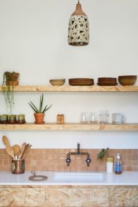 4 Beautifully Pair Down Kitchen Stuff on OvertheSink Wooden Shelves along with some Plain Plant Dcor