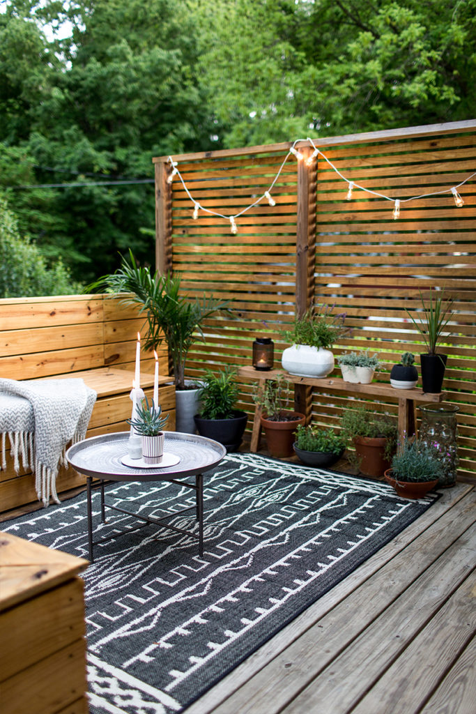 An Outdoor Renovation with Large Geometric Rug and Rustic Seating Furniture with Hidden Storage