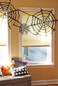Do this super cheap Halloween spiderweb wall decor with black trash bags